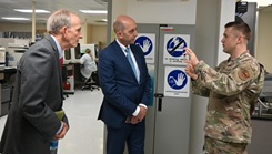 Genetics Reference Laboratory Flight Commander Maj. Joel Hughes shows Dr. David Smith, Acting Director, Defense Health Agency, and Dr. Stephen Ferrara, Acting Assistant Secretary of Defense for Health Affairs, a vial containing genetic material during their tour of the Department of Defense’s sole germline clinical genetics laboratory at Keesler Medical Center