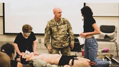 A soldier trains civilian medical students.