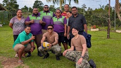 Military personnel posing for a picture after playing volleyball