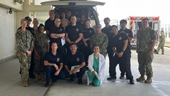 Class participants and instructors pose for a picture in the USNHO ambulance bay. 