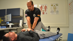 Dr. Jon Lopez, top, chiropractic physician at U.S. Army Health Clinic Vilseck, performs an adjustment on Sgt. Robert-Michael Osorio, Soldier with 1st Battalion, 4th Infantry Regiment, during Lopez's regular visit to U.S. Army Health Clinic Hohenfels Dec. 15, 2023.  (U.S. Army photo by Bryan Gatchell, USAG Bavaria Public Affairs) 