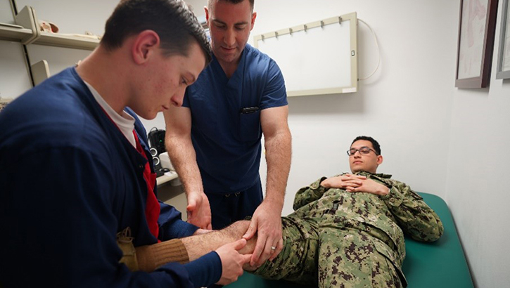 U.S. Navy Cmdr. Daniel Griffin, an orthopedic surgeon at Navy Medicine and Readiness Training Command Rota, Spain, demonstrates orthopedic assessment skills to U.S. Navy Hospitalman Jaxon Drezek, during a readiness training exercise. 