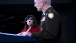 Military personnel talking at a podium