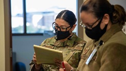 Military personnel taking notes on MHS GENESIS