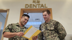 Two military dentists looking at a patient's file