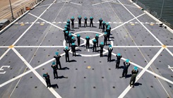 Military personnel for a teal ribbon on a flight deck