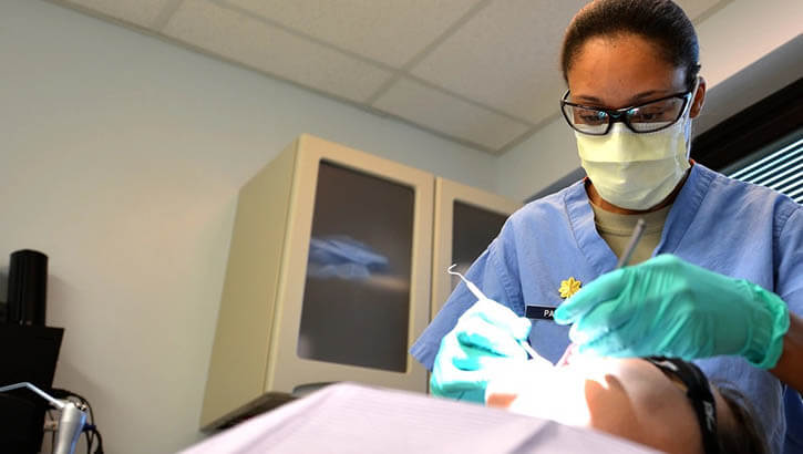 Image of U.S. Air Force Major Rachael Parrish, 20th Dental Squadron general dentist, performs an oral exam on Airman 1st Class Amie Bickford, 20th Equipment Maintenance Squadron munitions technician at Shaw Air Force Base, South Carolina, March 13, 2017. Airmen assigned to the 20th DS are tasked with ensuring airmen and soldiers on base meet all dental class requirements for deployment.