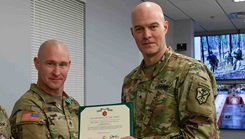 U.S. Army Staff Sgt. Anthony Nielsen, left, receives the Army Commendation Medal from U.S. Army Brig. Gen. Rhett R. Cox, right, the commanding general of Army Counterintelligence Command, during the Best Squad Competition Awards Ceremony