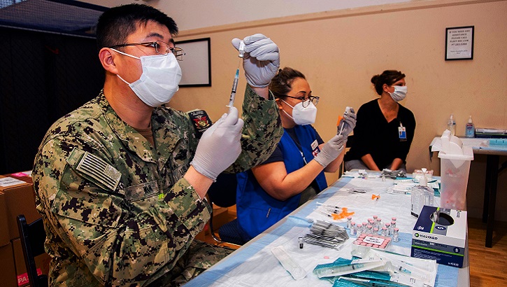 Image of Two medical people prepare syringes with doses of the COVID-19 vaccine .