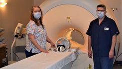 Military personnel posing by a medical machine