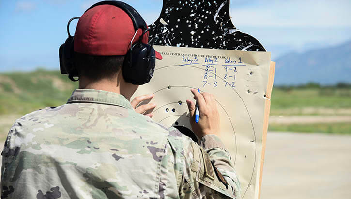 Image of An Air Force Airman inspects a target used during a shooting competition at Davis-Monthan Air Base, Arizona, in 2021. The True North program is a resilience program that embeds providers and spiritual leaders within squadrons and groups. Davis-Monthan implemented True North in October 2020. (Photo: Air Force Airman 1st Cl. William Turnbull).