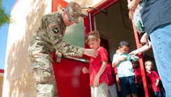 U.S. Army Maj. Justin Orton, clinical psychologist at William Beaumont Army Medical Center, pins a green ribbon in support of Mental Health Awareness Month on a student during a wellness walk at Bliss Elementary School in Fort Bliss, Texas. (Photo credit by Marcy Sanchez, William Beaumont Army Medical Center)