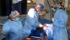 U.S. Navy Cmdr. (Dr.) Eric H. Twerdahl, part of the USU-WRNMMC surgery team, performs surgery in one of WRNMMC's hybrid operating rooms in July 2022