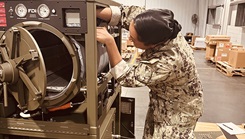 HM2 Nive Hamilton, an NMRLC Biomedical Technician, works on the Automated Field Steam Sterilizer