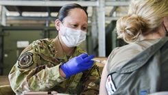 Military medical personnel administers vaccine to Soldier