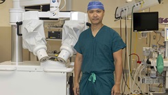 U.S. Army Col. (Dr.) Paul Hwang, director for surgery at Walter Reed, stands next to the microsurgical system used at the medical center for perform a successful breast reconstruction. (Graphic image by Roan Smith)