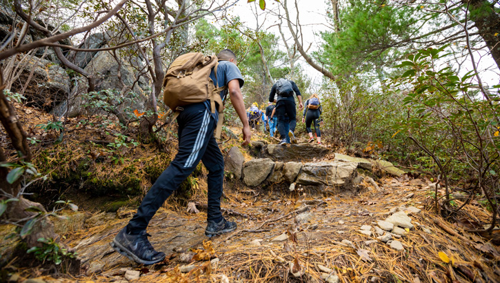 Image of Marines in civilian clothes hiking in mountains.