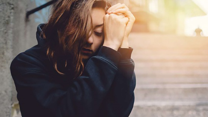 Image of A woman holding her hands near her face.