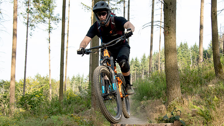 Image of A mountain biker wearing a helmet bikes through hard terrain.