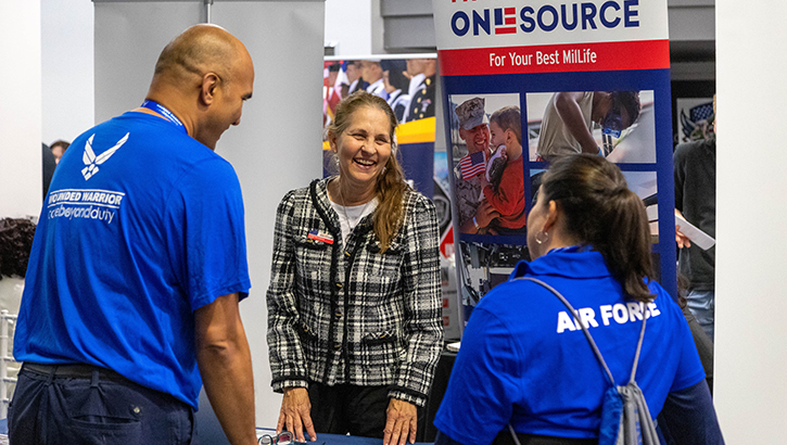 Image of A recovering Airman and caregiver talk with organizations during an Air Force Wounded Warrior CARE Event.