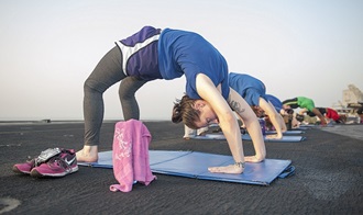 Link to Photo: Navy Petty Officer 3rd Class Tara Paradiso participates in a sunrise yoga class on the flight deck aboard the aircraft carrier USS Theodore Roosevelt. If you’re thinking of adding exercise to your pain management plan, consider the following types: aerobic, strength, and flexibility. But make sure your exercise program is specifically tailored to your needs. Some exercises might be easier or more difficult to complete depending upon the type and location of your pain. (U.S. Navy photo by Mass Communication Specialist 2nd Class Chris Liaghat)