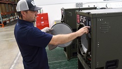 Joseph Wargo performs maintenance on a steam sterilizer