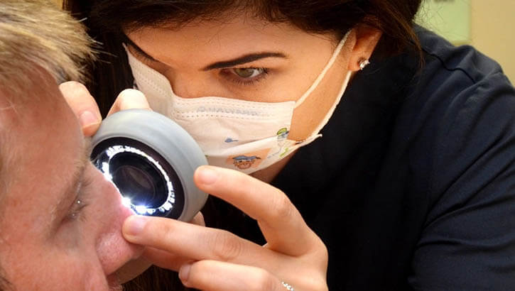 Image of Elizabeth Anderson, a physician assistant at Naval Hospital Jacksonville’s Dermatology Clinic, uses a lighted scope to check a patient’s skin. “Skin cancer rates are high in Florida, and it’s important to self-check monthly,” Anderson said. Skin cancer is the most common cancer in the U.S. To reduce risk, protect your skin from UV rays from the sun, tanning booths, and sunlamps.