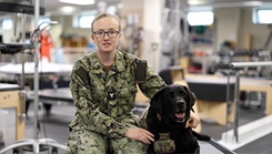 Hospital Corpsman 3rd Class Anna Burke , a dog handler at Walter Reed National Military Medical Center, speaks on the impacts of facility dogs at Walter Reed in the Military Advanced Training Center at Walter Reed in Bethesda, Maryland, June 28, 2023. 