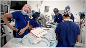 Link to Video: Military personnel doctors in an operating room working on a patient